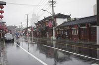 a woman walks through an alley in the rain holding an umbrella on a rainy day