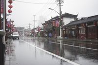 a woman walks through an alley in the rain holding an umbrella on a rainy day