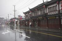 a woman walks through an alley in the rain holding an umbrella on a rainy day