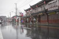 a woman walks through an alley in the rain holding an umbrella on a rainy day