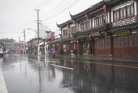 a woman walks through an alley in the rain holding an umbrella on a rainy day