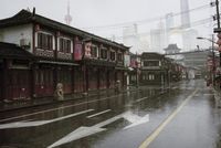 a woman walks through an alley in the rain holding an umbrella on a rainy day