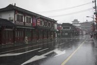 a woman walks through an alley in the rain holding an umbrella on a rainy day