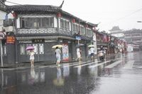 a woman walks through an alley in the rain holding an umbrella on a rainy day