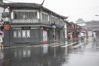 a woman walks through an alley in the rain holding an umbrella on a rainy day