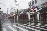 a woman walks through an alley in the rain holding an umbrella on a rainy day