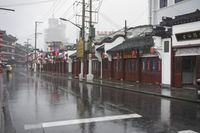 a woman walks through an alley in the rain holding an umbrella on a rainy day