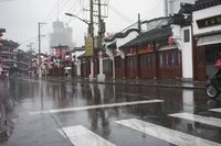 a woman walks through an alley in the rain holding an umbrella on a rainy day