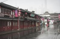 a woman walks through an alley in the rain holding an umbrella on a rainy day