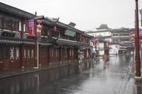 a woman walks through an alley in the rain holding an umbrella on a rainy day