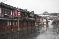 a woman walks through an alley in the rain holding an umbrella on a rainy day