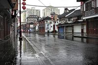 a woman walks through an alley in the rain holding an umbrella on a rainy day