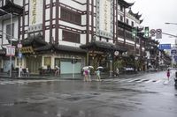 a woman walks through an alley in the rain holding an umbrella on a rainy day