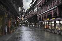 a woman walks through an alley in the rain holding an umbrella on a rainy day