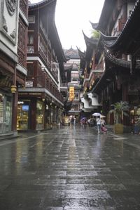 a woman walks through an alley in the rain holding an umbrella on a rainy day