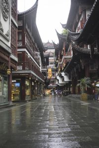 a woman walks through an alley in the rain holding an umbrella on a rainy day