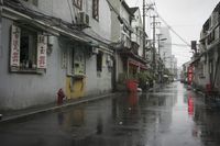 a woman walks through an alley in the rain holding an umbrella on a rainy day