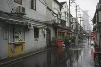 a woman walks through an alley in the rain holding an umbrella on a rainy day