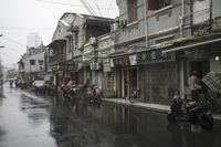 a woman walks through an alley in the rain holding an umbrella on a rainy day