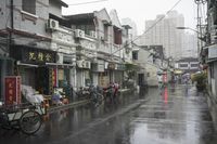 a woman walks through an alley in the rain holding an umbrella on a rainy day