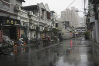 a woman walks through an alley in the rain holding an umbrella on a rainy day