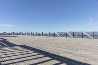 a balcony is overlooking a lake in the distance and mountains in the background on the right