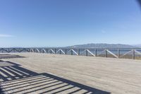 a balcony is overlooking a lake in the distance and mountains in the background on the right