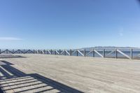 a balcony is overlooking a lake in the distance and mountains in the background on the right