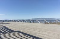 a balcony is overlooking a lake in the distance and mountains in the background on the right