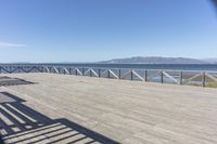 a balcony is overlooking a lake in the distance and mountains in the background on the right