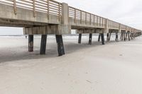 this wooden bridge is made to hold people across the beach for walking or kayaking