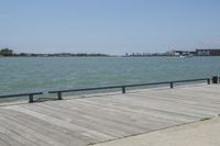 a wooden dock with a view of the water from the pier on a clear day