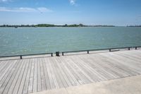 a wooden dock with a view of the water from the pier on a clear day