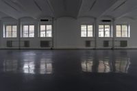 large empty room with several windows that are opened up and there is the floor tileed