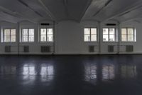 large empty room with several windows that are opened up and there is the floor tileed