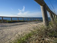 two long wooden poles sitting on top of a gravel covered beach next to the ocean