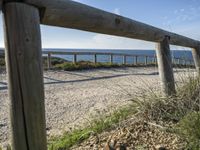 two long wooden poles sitting on top of a gravel covered beach next to the ocean