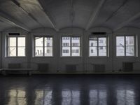 a black and white picture of a room full of windows and benches by the window