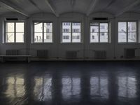 a black and white picture of a room full of windows and benches by the window