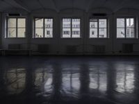 a black and white picture of a room full of windows and benches by the window
