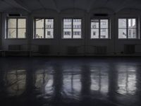 a black and white picture of a room full of windows and benches by the window