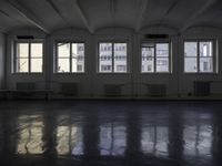 a black and white picture of a room full of windows and benches by the window