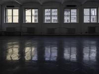 a black and white picture of a room full of windows and benches by the window