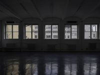 a black and white picture of a room full of windows and benches by the window