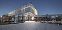 an office building designed with glass walls and white tiles, outside the front is a fountain