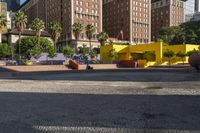 a yellow brick building sitting in the middle of a city street with tall buildings and some traffic