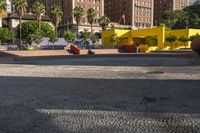 a yellow brick building sitting in the middle of a city street with tall buildings and some traffic