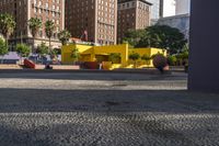 a yellow brick building sitting in the middle of a city street with tall buildings and some traffic