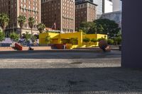 a yellow brick building sitting in the middle of a city street with tall buildings and some traffic