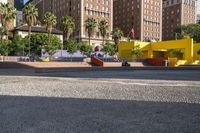 a yellow brick building sitting in the middle of a city street with tall buildings and some traffic